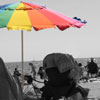 Rainbow umbrella on beach, black and white