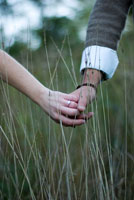 couples holding hands in the field